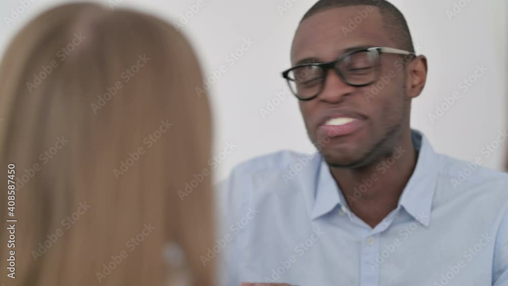 Rear View of Happy African Man Talking to Caucasian Woman Rear View of Happy African Man Talking to Caucasian Woman