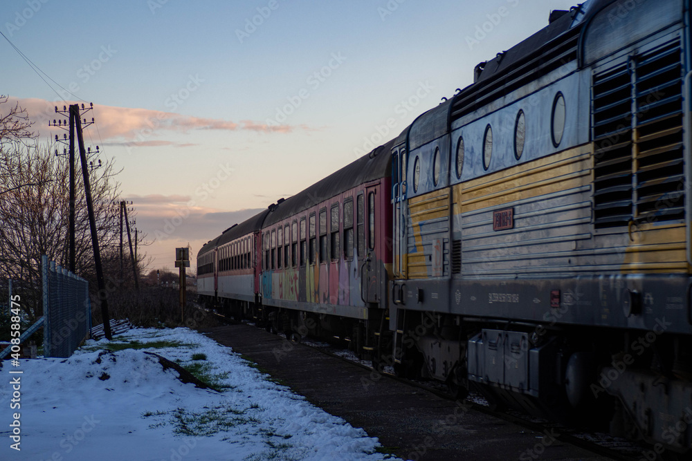 Obraz premium Old diesel locomotive carrying retro passenger wagons 