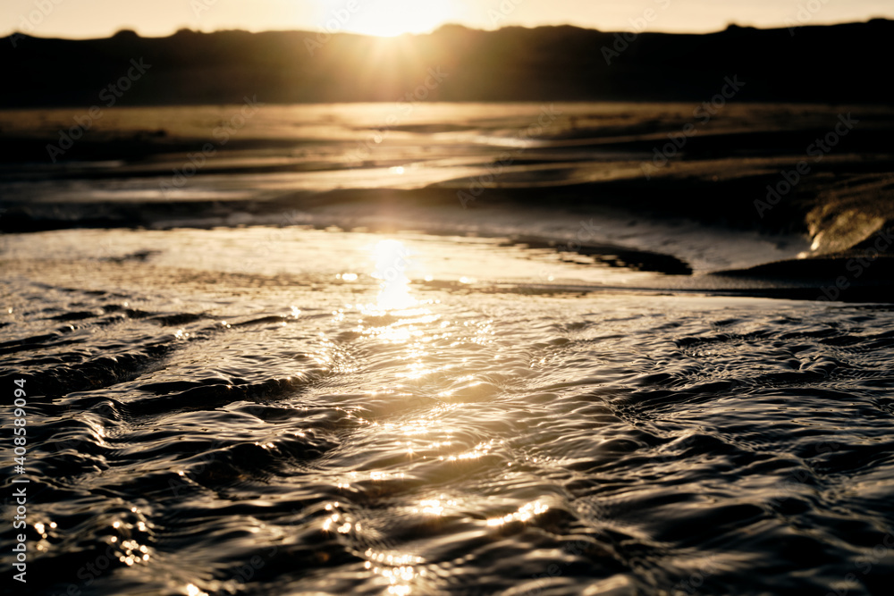 Small waves on the beach due to the changing of the tide during sunrise. Small waves on the beach due to the changing of the tide during sunrise.