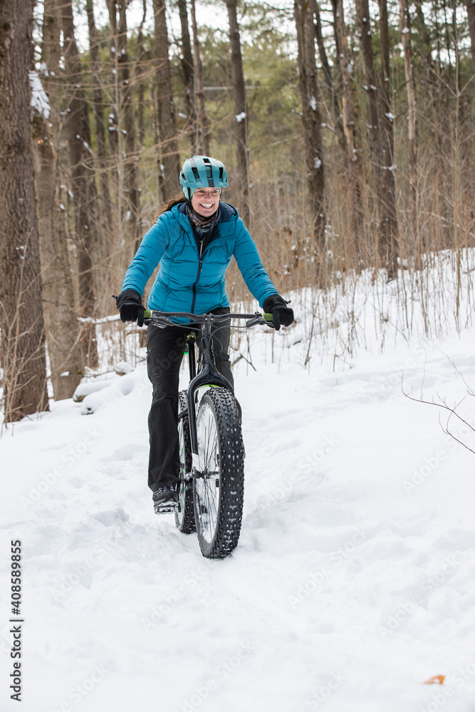 Attractive woman rides her fat bike in the snow
