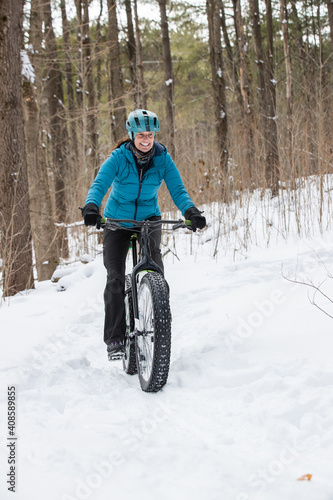 Obraz na płótnie Attractive woman rides her fat bike in the snow w salonie