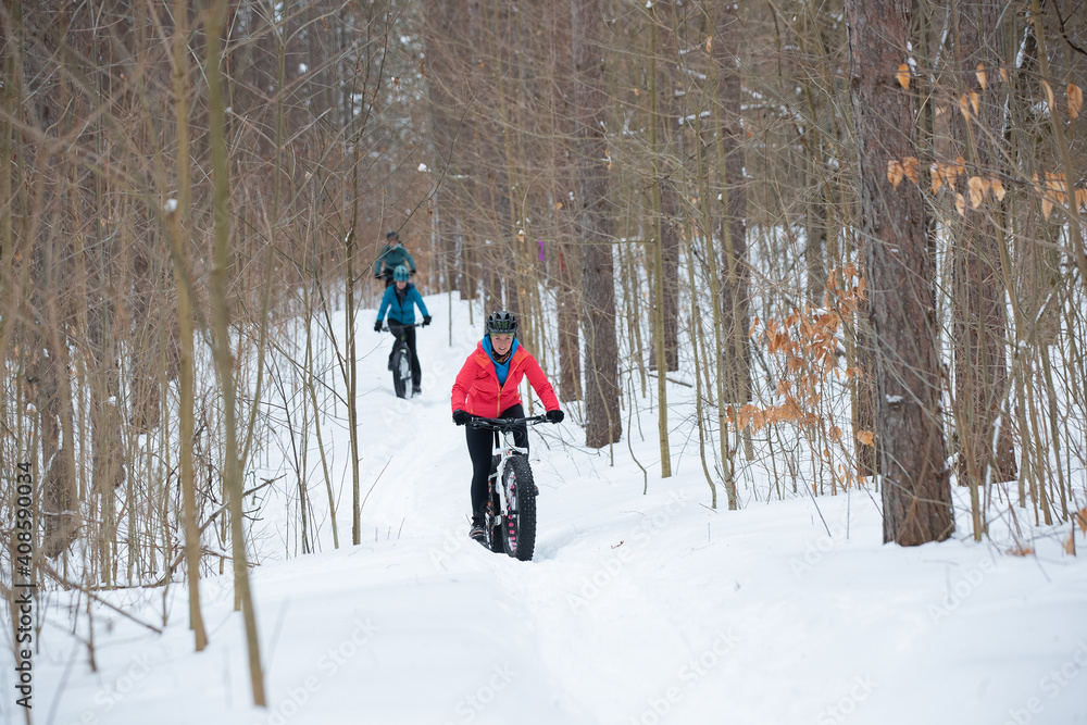 Group of attractive women riding fat bikes in the snow