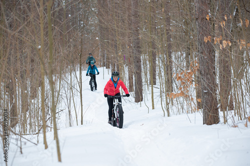 Group of attractive women riding fat bikes in the snow