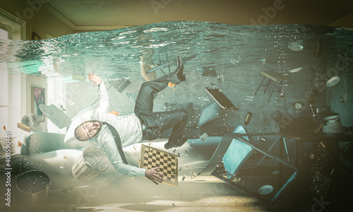 man in trouble in a flooded room of his home. photo