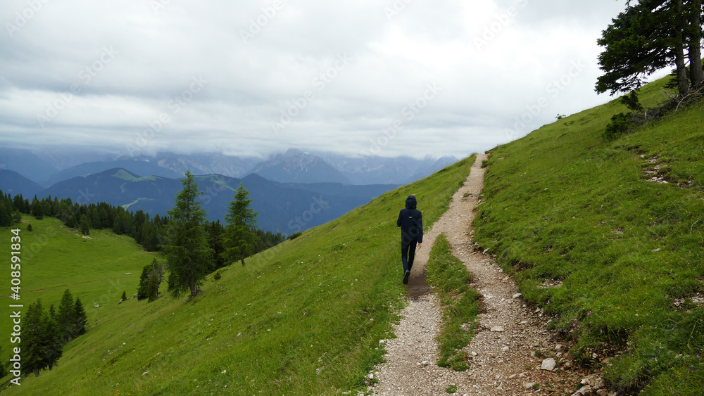 Young man alone on the hiking trail in the Alps