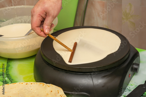 Slika na platnu Cooking breakfast in an electric pancake pan