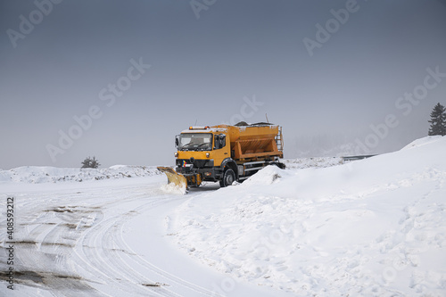 Snow plough truck cleaning a road through the mountains after winter massive snowfall