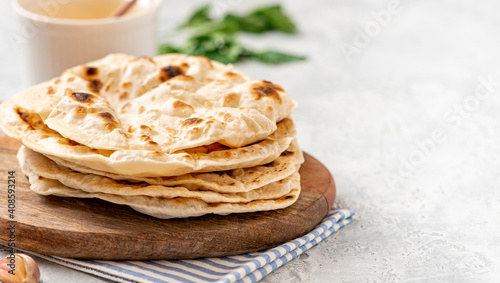 Homemade Roti Chapati Flatbread on gray concrete background. Freshly baked indian flatbread. Copy space for text.