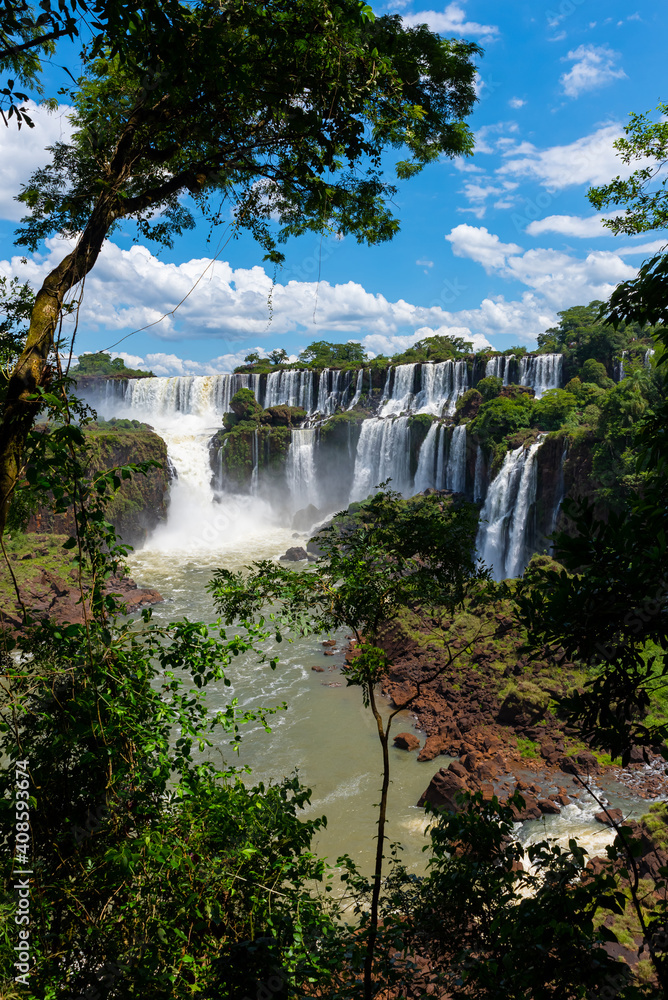 Wonderful vivid landscape of Iguazu Falls with water streams falling down among verdant vegetation in sunny day Wonderful vivid landscape of Iguazu Falls with water streams falling down among verdant vegetation in sunny day