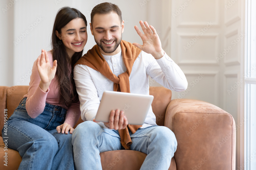 Arab Couple Video Calling Using Digital Tablet Sitting At Home Arab Couple Video Calling Using Digital Tablet Sitting At Home