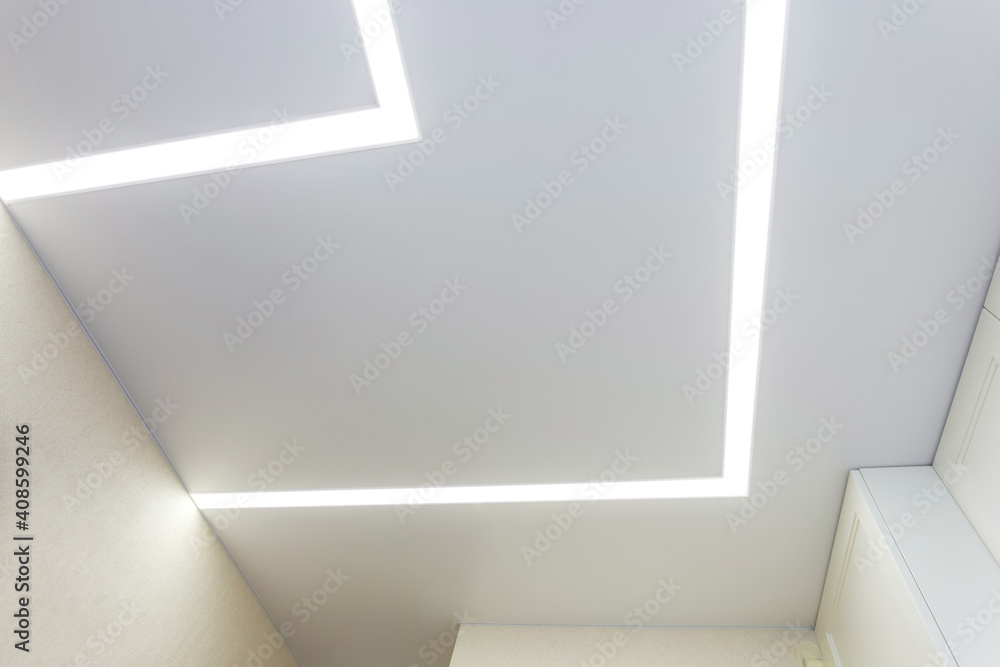 Fototapeta premium suspended ceiling with halogen spots lamps and drywall construction in empty room in apartment or house. Stretch ceiling white and complex shape.