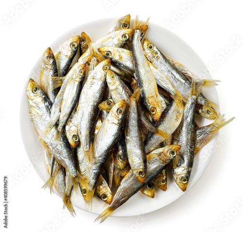 Dried smoked small fish on a plate on a white background, tulka isolated. Top view photo