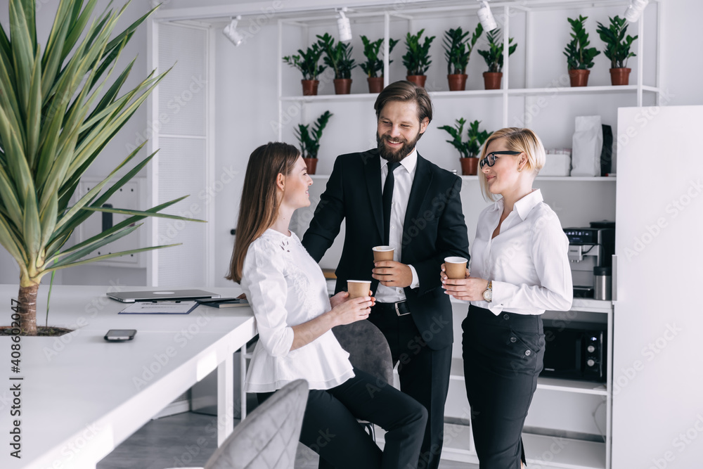 Happy colleagues have fun at lunch break in the office drinking coffee. Happy colleagues have fun at lunch break in the office drinking coffee.
