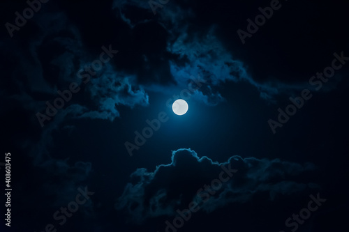 Photography full moon in the night sky among the clouds.