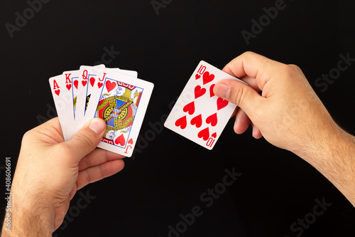 Fotografía Man hands holding combination of royal flush poker cards on dark background