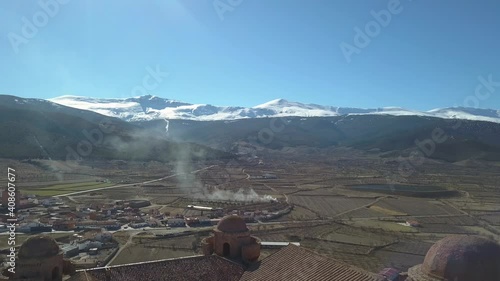 Aerial descending shot with over the castle of La Calahorra with the mountain of Sierra Nevada behind. photo