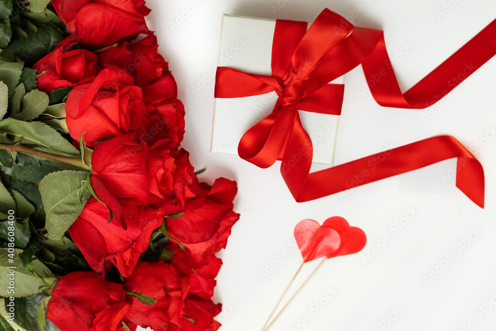bright scarlet bouquet of roses, gift box with a bright ribbon on a white background with a place for text, greeting card concept happy Valentine's day, March 8, happy birthday - obrazy, fototapety, plakaty 