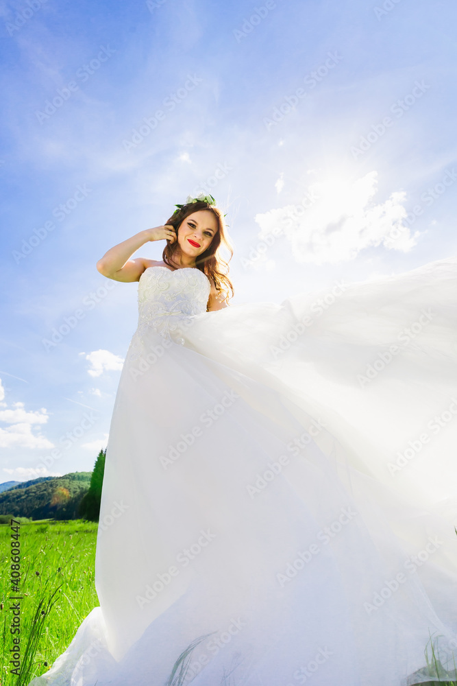 Young beautiful brunette woman walks in the meadow. Luxurious elegant vintage wedding white princess dress. Young beautiful brunette woman walks in the meadow. Luxurious elegant vintage wedding white princess dress.