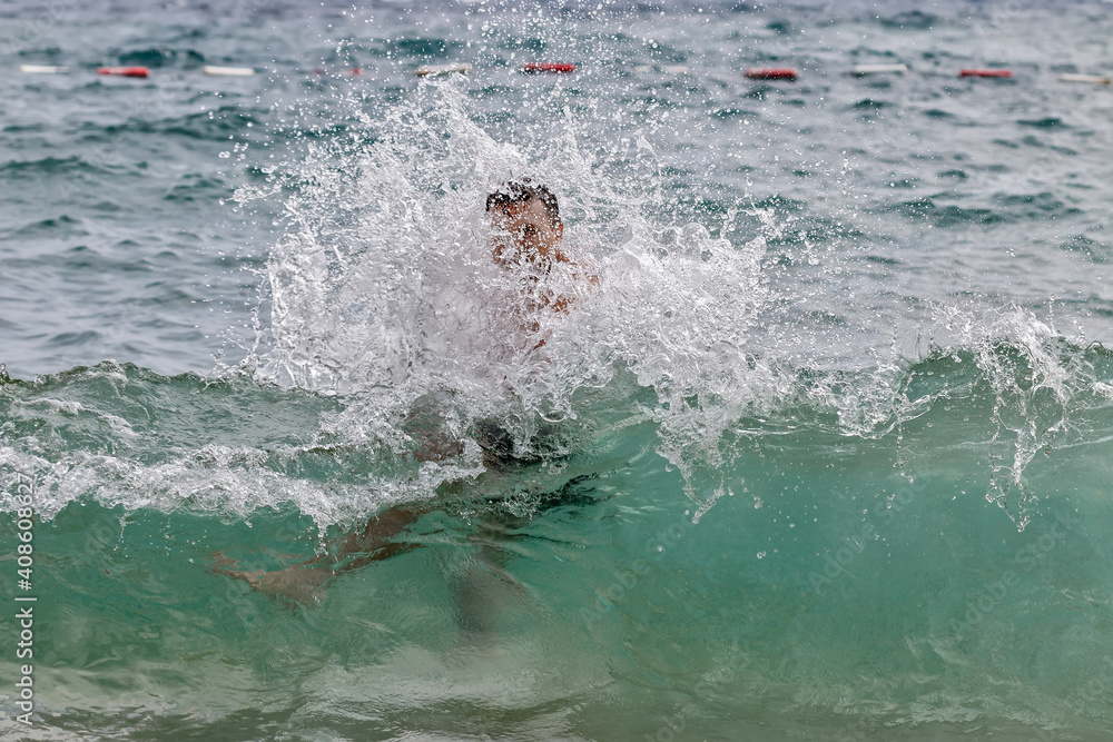 Fototapeta premium The guy bathes in the sea. Big waves