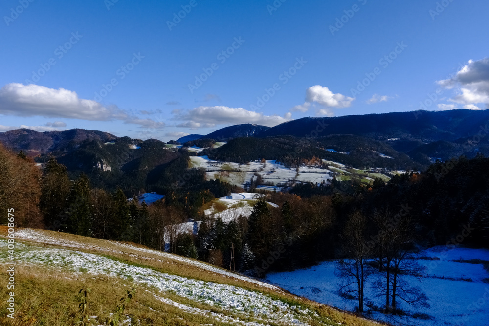 landscape with green hills and the first snow in november
