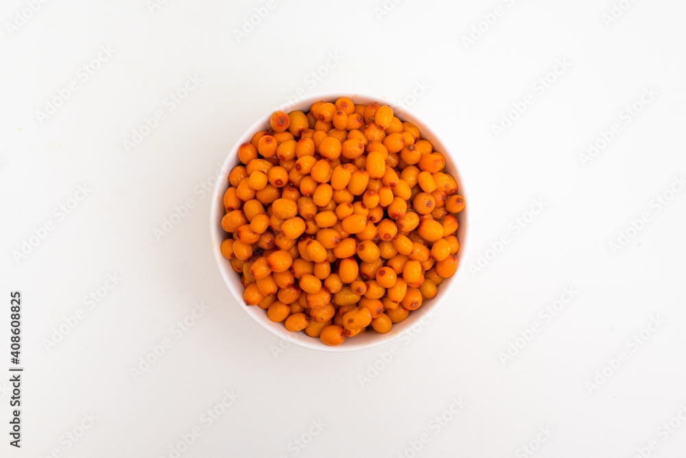 Bowl with sea buckthorn berries on a white background. View from above. Bowl with sea buckthorn berries on a white background. View from above.