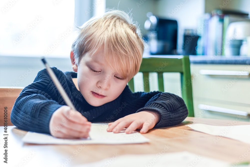 Child doing homework at the kitchen table at home during lockdown Child doing homework at the kitchen table at home during lockdown