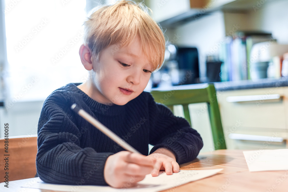 Child doing homework at the kitchen table at home during lockdown Child doing homework at the kitchen table at home during lockdown