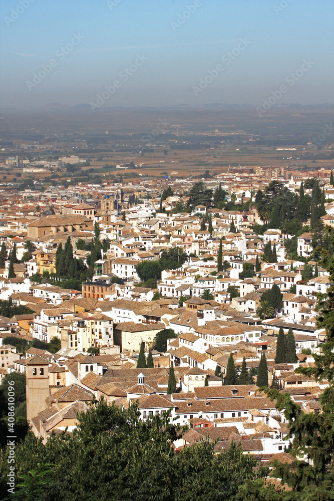 View of the city seen from the top of Alhambra Palace at Granada, Andalusia, Spain. The bird`s eye view of the city with lush greeneries looks beautiful on a sunny day