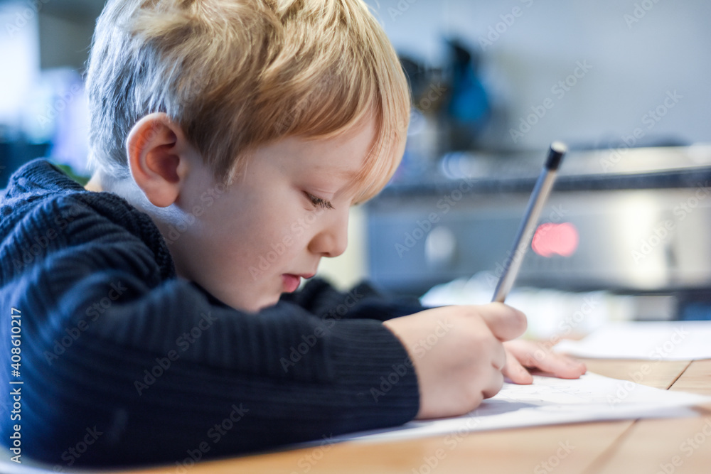 Child doing homework at the kitchen table at home during lockdown Child doing homework at the kitchen table at home during lockdown