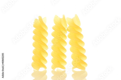 Bright yellow uncooked Fusilli pasta, close-up, isolated on white.