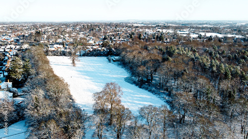 Snow covered public park and wood land forest scene from aerial drone
