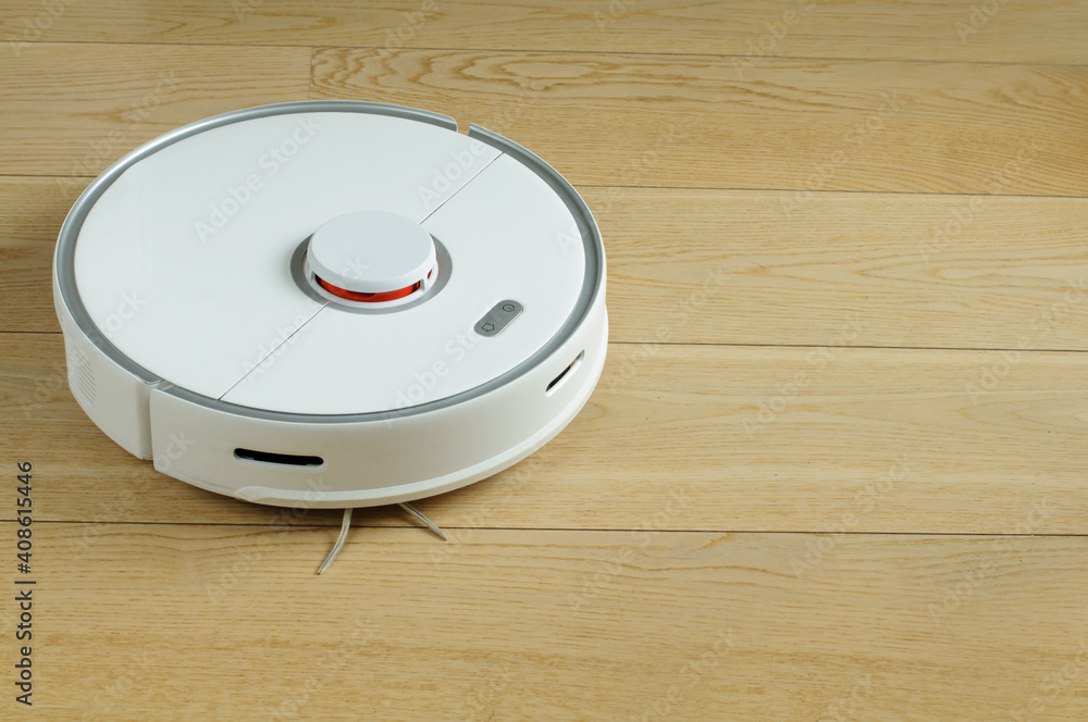 robot vacuum cleaner in the process of cleaning a room on a light wooden parquet robot vacuum cleaner in the process of cleaning a room on a light wooden parquet