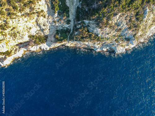 Aerial drone view over western Alonnisos towards Skopelos island at sunset. Natural landscape, beautiful rocky scenery, in Sporades, Aegean sea, Greece © panosk18