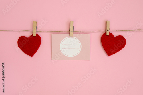 Blank love letter pegged to a line with red hearts. Valentine's day, mother's day.