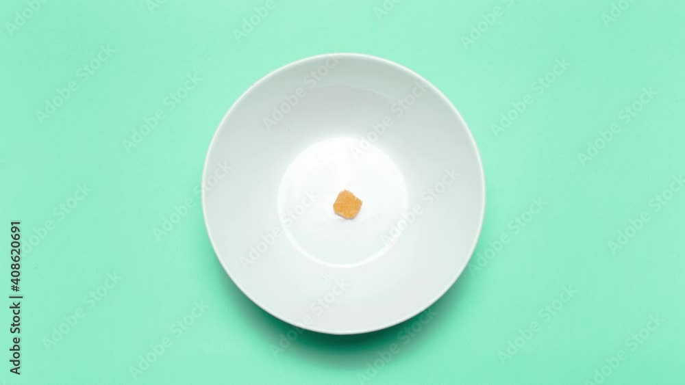 Stop motion animation photography. Top view of corn puff snacks, disappear from the white bowl on background of green color. Stop motion animation photography. Top view of corn puff snacks, disappear from the white bowl on background of green color.