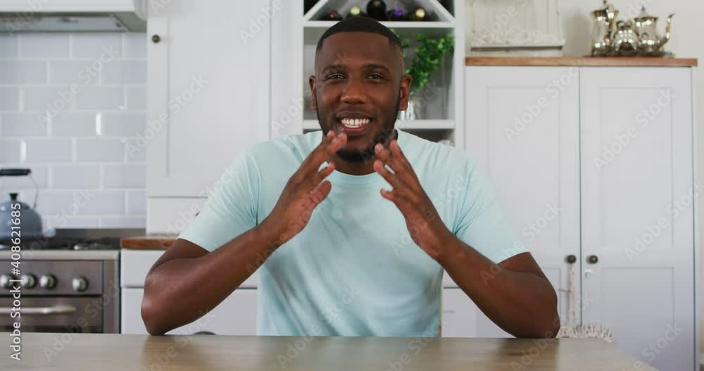 African american man looking to camera talking on video call in kitchen African american man looking to camera talking on video call in kitchen