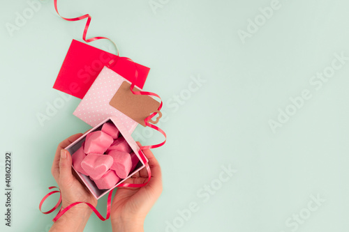 Happy Valentines Day. Gift box with pink chocolate hearts, gift card and ribbon. With copy space and top view