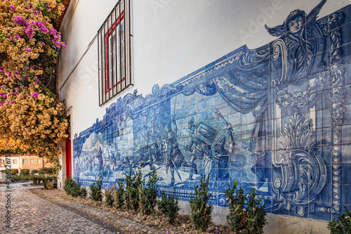 Fotografie A wall of a traditional Portuguese house in Lisbon decorated by blue azulejo tiles showing the battle scene