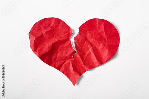 Crumpled and torn red heart shape paper isolated on white background. Broken heart concept.