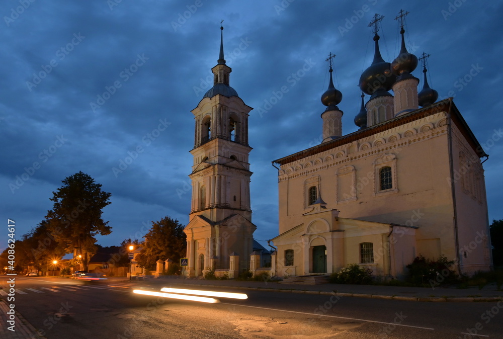 Evening view of ancient orthodox church with traffic lights and dramatic deep-blue cloudy sky. Smolenskiy temple in the town of Suzdal, Russian 