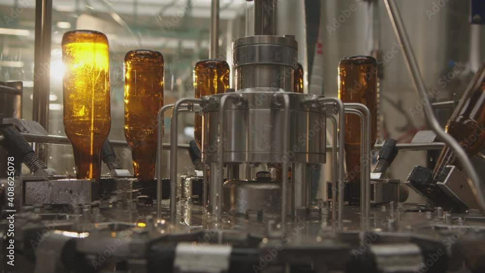 Washing process of empty beer brown bottles in a factory. Modern industrial machines in a brewery. Factory, brewery concept. Washing process of empty beer brown bottles in a factory. Modern industrial machines in a brewery. Factory, brewery concept.
