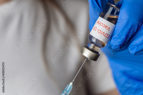 Closeup hand of woman doctor or scientist in lab hold medicine liquid vaccine vial bottle and syringe, coronavirus or COVID-19 concept