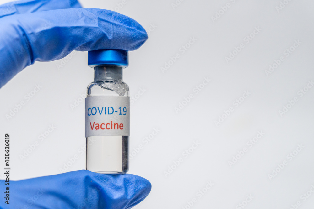 Bottle with vaccine against covid 19 in hand of researcher wearing gloves. Vial with coronavirus vaccine developed for protection against COVID-19. Healthcare and medical concept. Bottle with vaccine against covid 19 in hand of researcher wearing gloves. Vial with coronavirus vaccine developed for protection against COVID-19. Healthcare and medical concept.