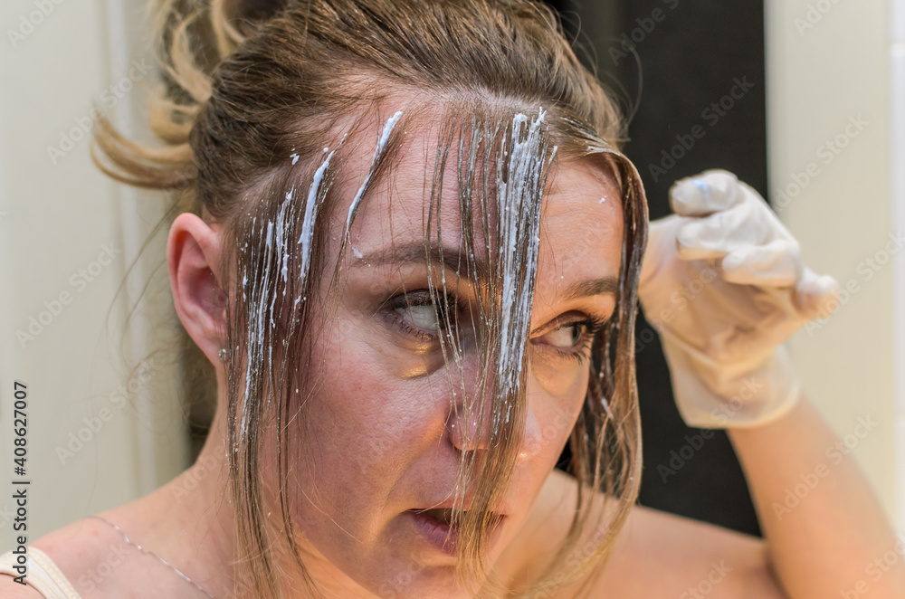 Naklejka premium Young woman dyes her hair