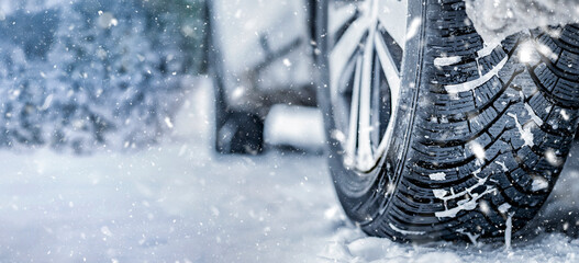Winter tire. Detail of car tires in winter on the road covered with snow. Panorama, banner