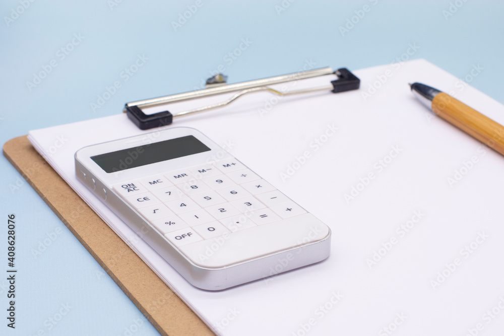 paper with a pen and calculator on a blue background. The concept of the transience of time. Business concept paper with a pen and calculator on a blue background. The concept of the transience of time. Business concept