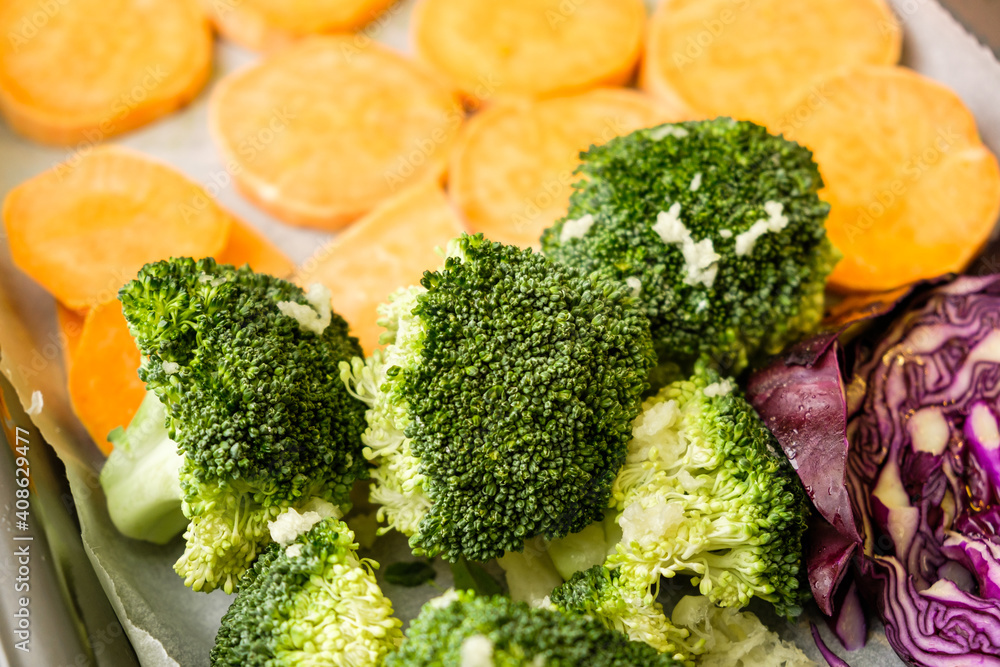 Fresh vegetables sweet potato, broccoli, purple cabbage on the baking paper. Healthy meal 