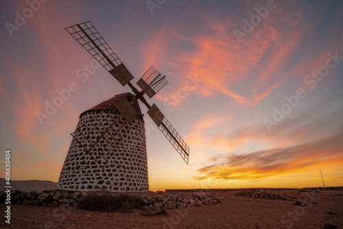 windmill with red lights at sunset