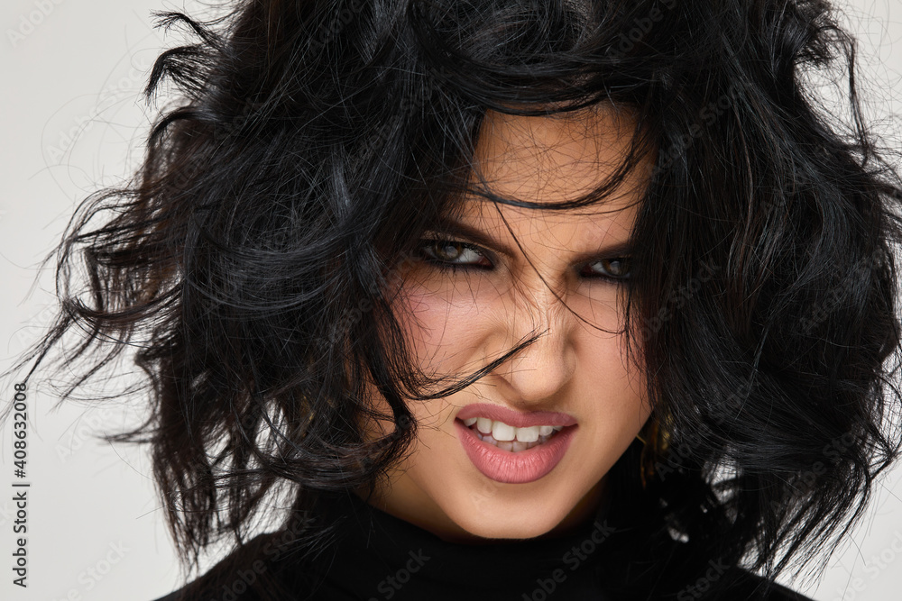 portrait of angry beautiful curly brunette woman on studio background portrait of angry beautiful curly brunette woman on studio background