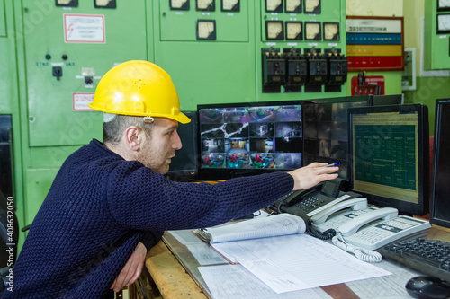 electrician with yellow helmet working in a power station